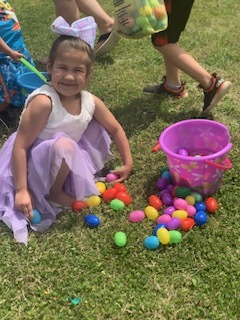 A young girl surrounded by colorful easter eggs